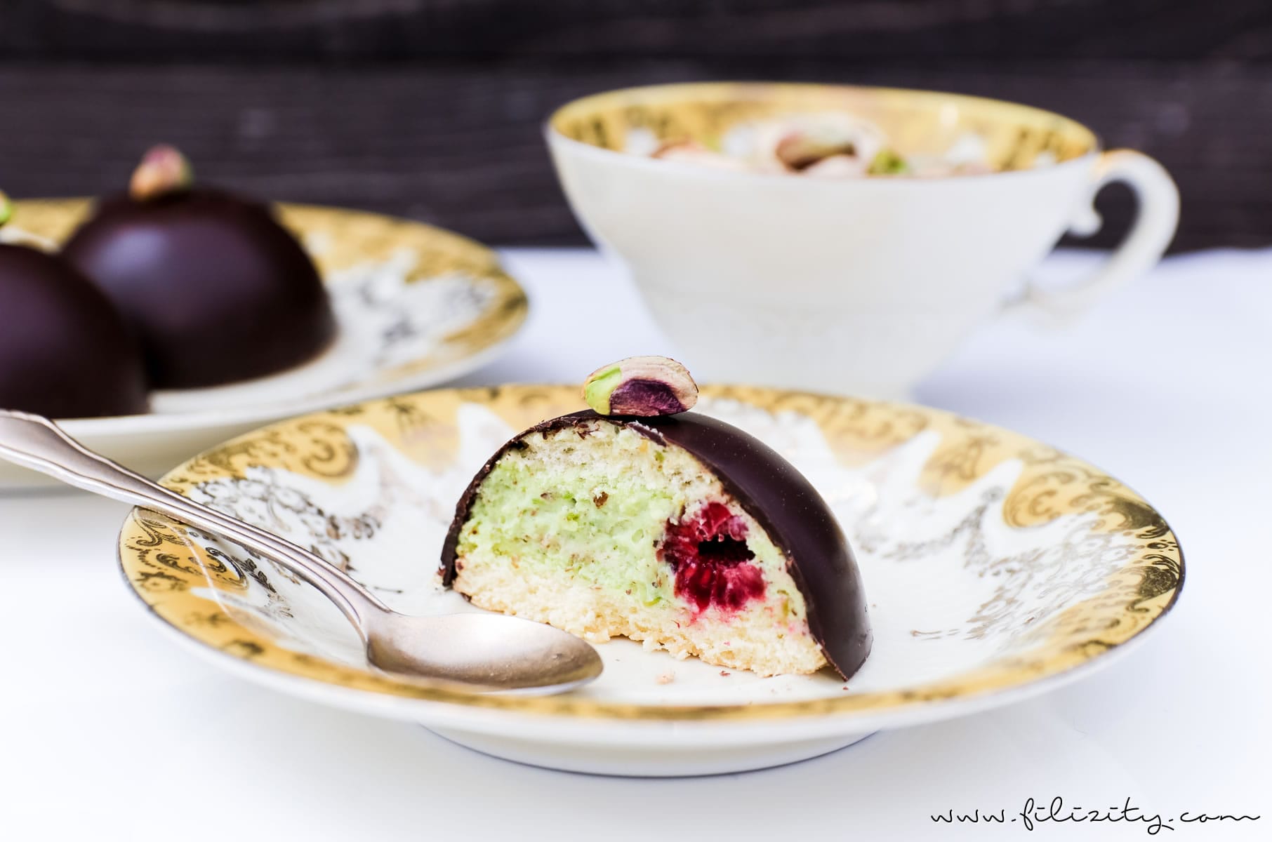 Pistazien-Törtchen mit Himbeeren | Feine Schoko-Kuppel mit Pistaziencreme und Bikuit | Filizity.com | Food-Blog aus dem Rheinland #dessert #kuchen #schokolade